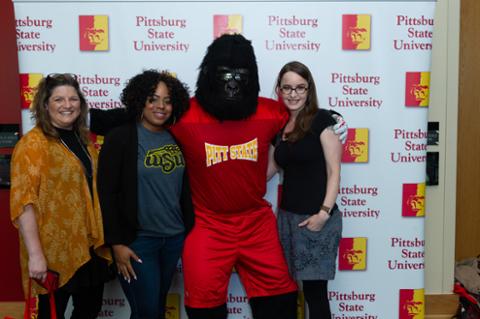 Gus the Gorilla and three female attendees smiling for the camera.
