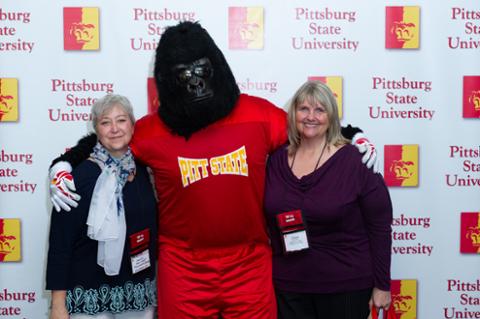 Gus the Gorilla and two older women smiling for the camera.