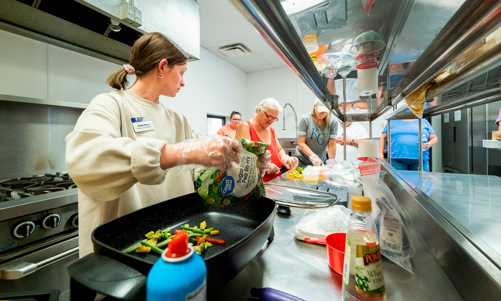 Student teaching cooking class in kitchen