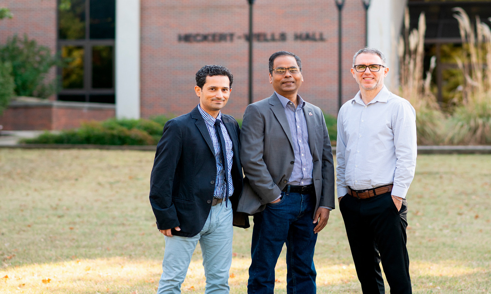 Three scientists pose together. 