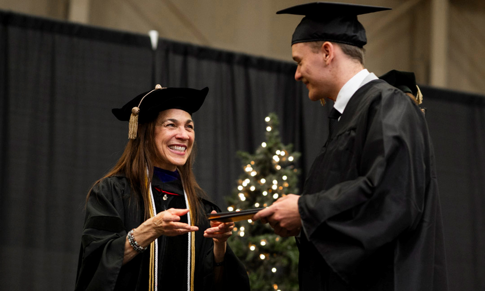 Commencement provost handing graduate his diploma