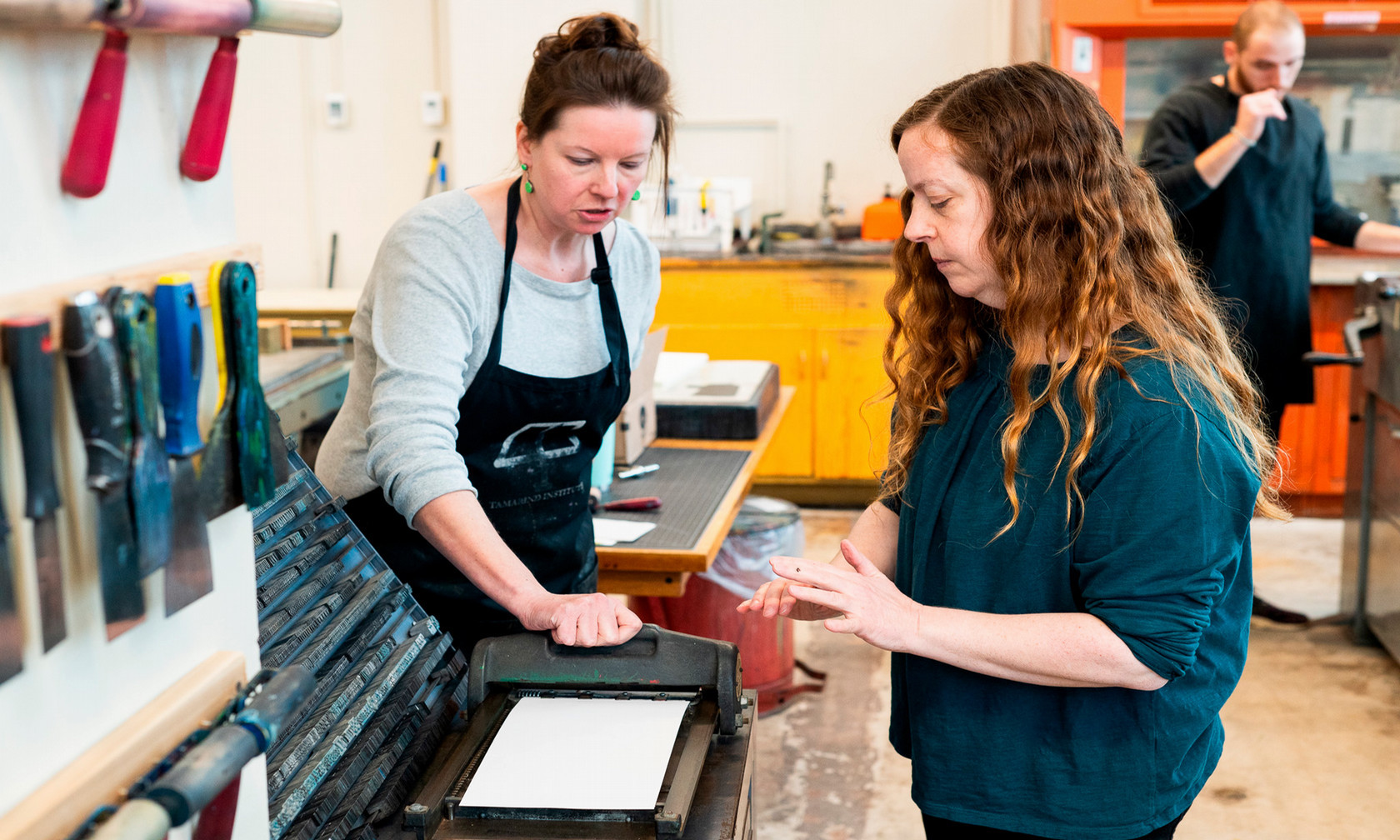 Two women working on printing press