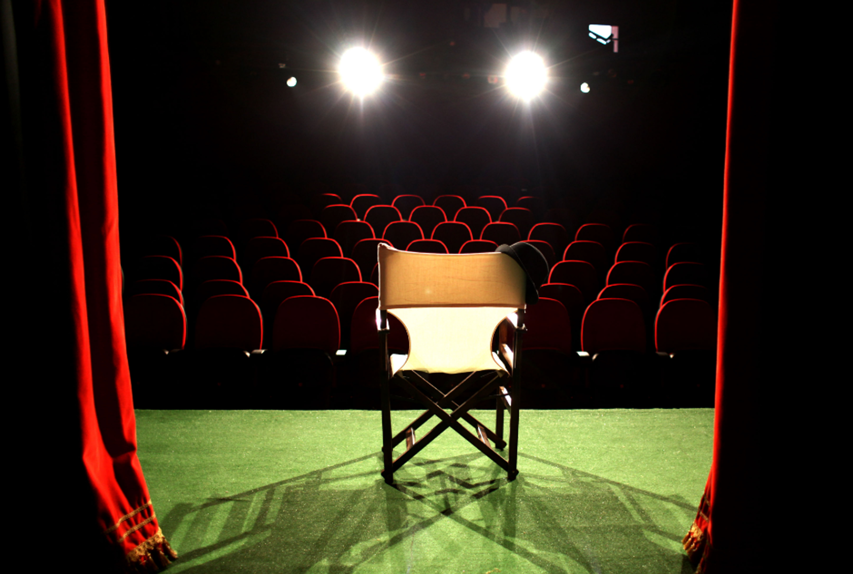 Stock photo from Canva. Chair on stage with dramatic lights
