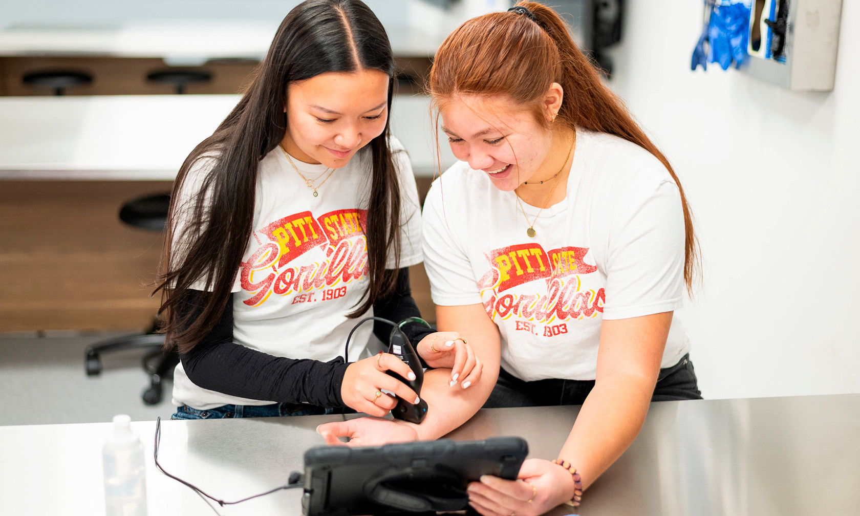 two premed students practicing ultrasound in lab