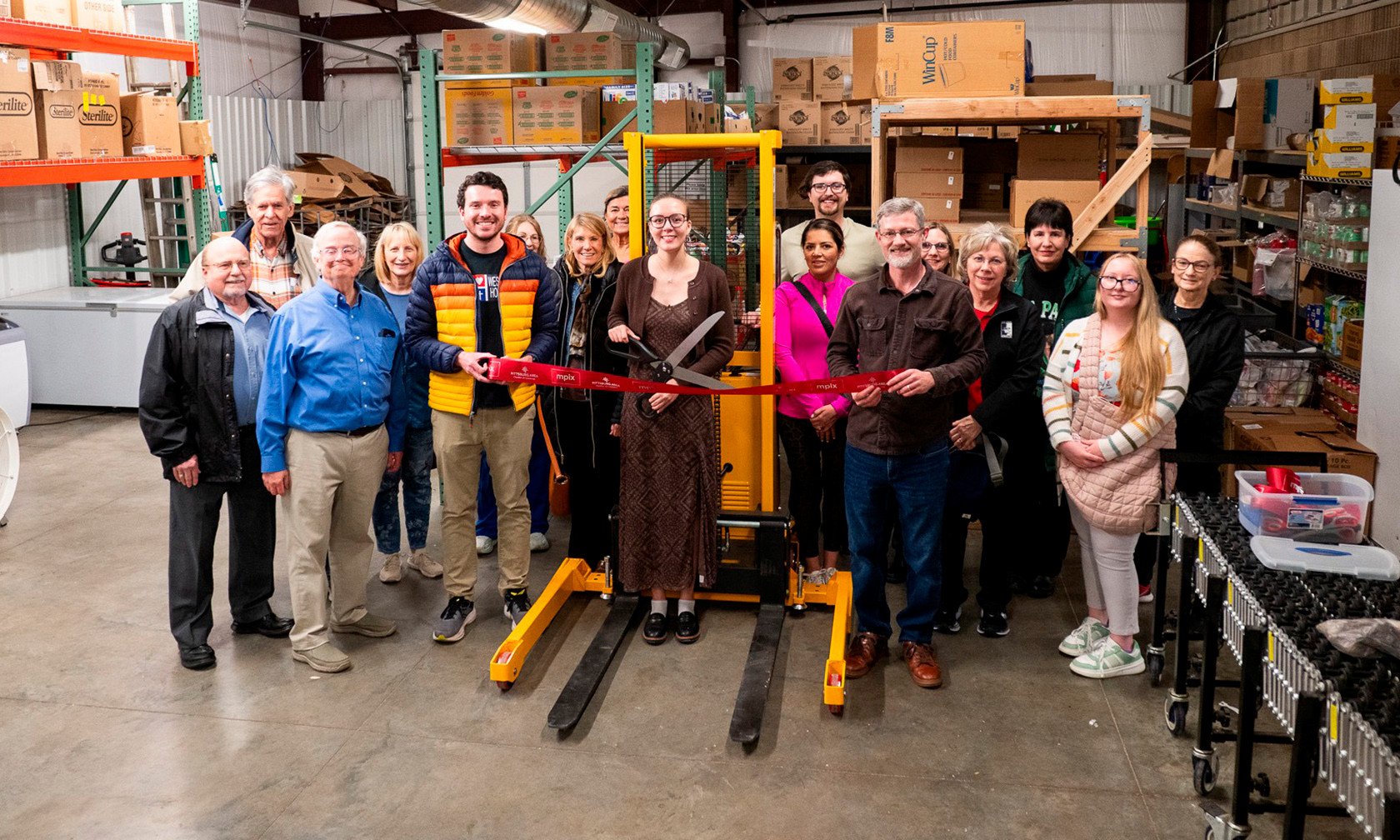 group of volunteers at Wesley House with pallet stacker a student raised funds for